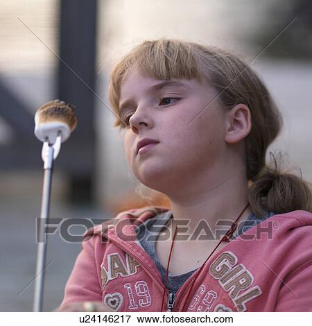 Girl looking at her toasted marshmellow at Lake of the Woods, Ontario View Large Photo Image Stock Photo - Girl looking at her toasted marshmellow at Lake of the Woods, Ontario. Fotosearch