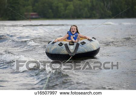 Girl water tubing on the lake at Lake of the Woods, Ontario View Large Photo Image Stock Photo - Girl water tubing on the lake at Lake of the Woods, Ontario. Fotosearch