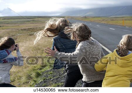 Stock Photography - Girls rear view on a windy day next to the highway. Fotosearch