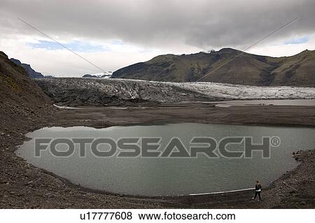 Glacier and glacial lake surrounded by mountains on cloudy day View Large Photo Image Stock Photo - Glacier and glacial lake surrounded by mountains on cloudy day. Fotosearch