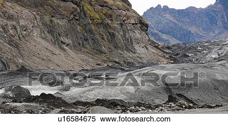 Stock Photography - Glacier moraine and debris, rocks ground into glacial flour, in craggy mountains. Fotosearch