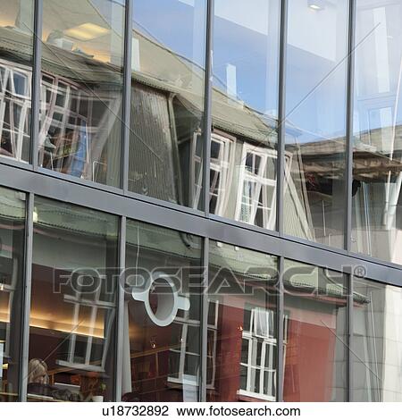 Stock Image - Glass office windows reflecting distorted building opposite. Fotosearch