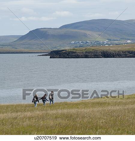 Hikers along the ocean coastline near village View Large Photo Image Stock Photo - Hikers along the ocean coastline near village. Fotosearch