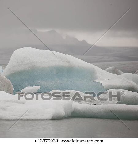 Iceberg floating in glacial lake View Large Photo Image Stock Photo - Iceberg floating in glacial lake. Fotosearch