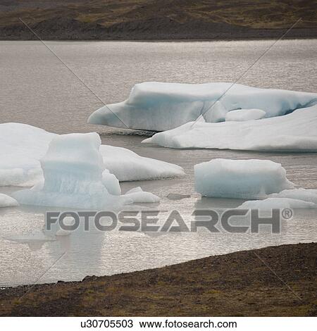 Stock Image - Icebergs floating offshore in a glacial lake. Fotosearch