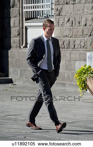 Stock Photography - Icelandic man in business suit and tie walking on the city sidewalk. Fotosearch