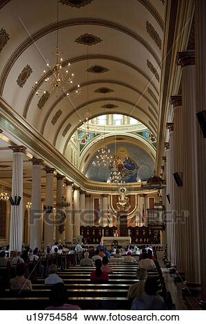 Picture - Interior of Metropolitan Cathedral of San Jose with worshippers facing the altar. Fotosearch