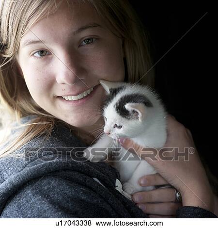 Stock Photo - Kitten cuddled by girl. Fotosearch