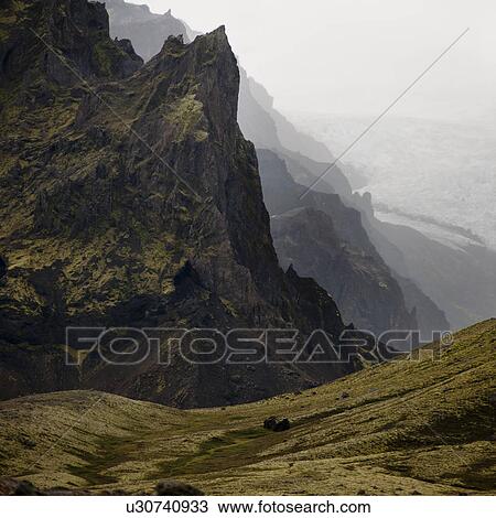 Stock Image - Landscape, craggy mountain valley overlooking glacier field. Fotosearch