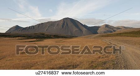 Landscape, dry grass pasture with road before eroded volcanic mountain View Large Photo Image Stock Photo - Landscape, dry grass pasture with road before eroded volcanic mountain. Fotosearch