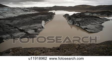 Stock Image - Landscape, glaciers melting in glacial lake, moraine at front. Fotosearch
