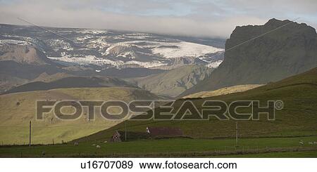 Stock Photo - Landscape, glaciers, mountains and farmland, with barns. Fotosearch