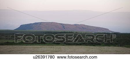 Stock Image - Landscape mountain range rising from grassland. Fotosearch