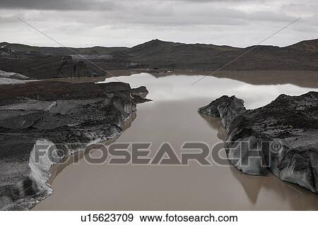 Stock Photo - Landscape of dirty melting glaciers in a glacial lake. Fotosearch