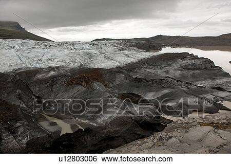 Stock Photograph - Landscape of dirty melting glaciers in a glacial lake. Fotosearch