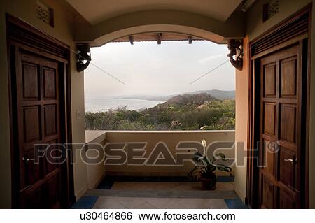 Stock Photograph - Landscape view of jungles of Costa Rica through a terrace doorway. Fotosearch
