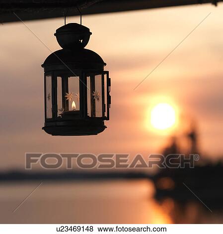 Stock Photo - Lantern with the sunset horizon at Lake of the Woods, Ontario. Fotosearch