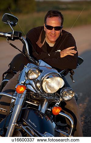 Man bending over his motorcycle View Large Photo Image Stock Photo - Man bending over his motorcycle. Fotosearch