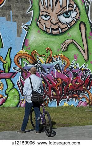Man looking at graffiti painted on a wall in Reykjavik Iceland View Large Photo Image Stock Photograph - Man looking at graffiti painted on a wall in Reykjavik Iceland. Fotosearch