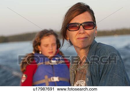 Mother and daughter with the sunlight in their face while riding in a boat at Lake of the Woods, Ontario View Large Photo Image Stock Image - Mother and daughter with the sunlight in their face while riding in a boat at Lake of the Woods, Ontario. Fotosearch