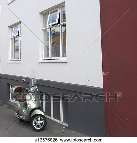 Stock Photograph - Motorscooter parked beside building. Fotosearch
