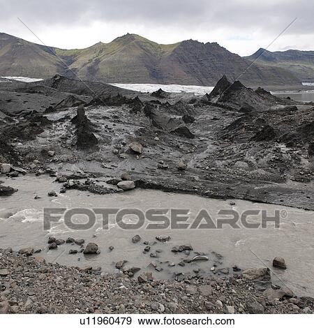 Stock Photo - Mountain, glacier icefield and muddy runoff stream. Fotosearch