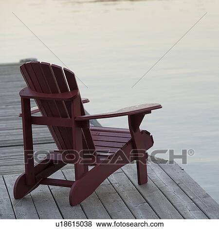 Stock Photo - Muskoka chair on dock at Lake of the Woods, Ontario. Fotosearch