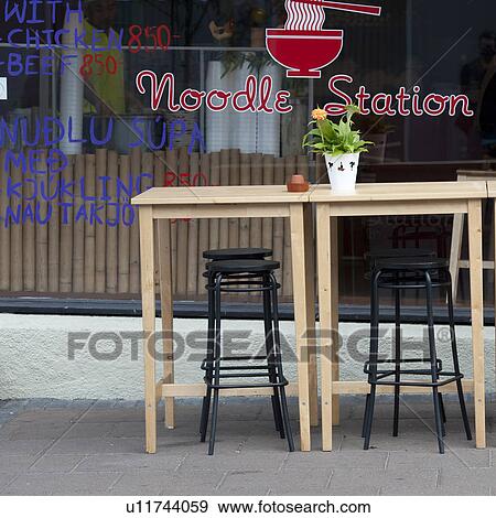 Stock Photo - Outdoor sidewalk cafe table and stools. Fotosearch