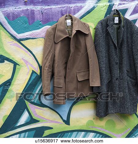 Overcoats hanging on graffiti painted walls View Large Photo Image Stock Photo - Overcoats hanging on graffiti painted walls. Fotosearch