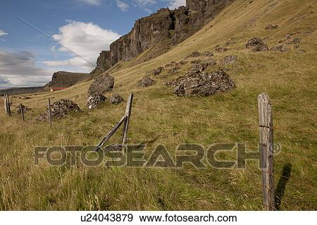 Pastureland on scree mountainside with rock outcrop and barbed wire fence View Large Photo Image Stock Photo - Pastureland on scree mountainside with rock outcrop and barbed wire fence . Fotosearch
