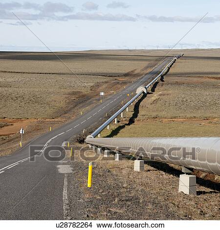 Picture - Pipeline alongside barren grassland highway. Fotosearch