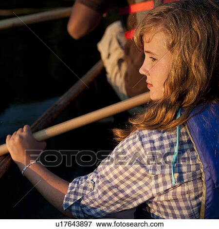 Stock Photo - Profile of a young girl paddling in a canoe at Lake of the Woods, Ontario. Fotosearch