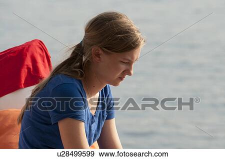 Stock Photo - Profile of teenage girl looking downwards at Lake of the Woods, Ontario. Fotosearch