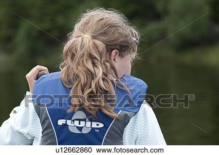 Stock Image - Rear view of a girl wearing a life jacket in a canoe at Lake of the Woods, Ontario . Fotosearch
