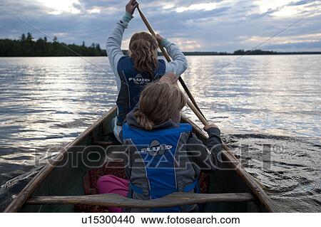 Rear view of two girls wearing life jackets in a canoe at Lake of the Woods, Ontario View Large Photo Image Stock Image - Rear view of two girls wearing life jackets in a canoe at Lake of the Woods, Ontario . Fotosearch