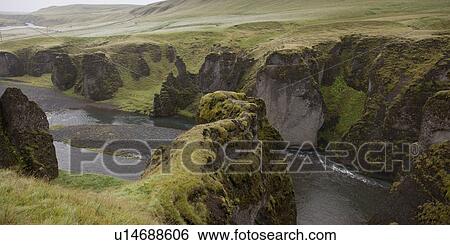 Stock Photograph - River gorge valley cut through grasslands with steep eroded cliffs. Fotosearch