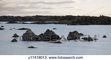 Rocks rising from the water along shore of lagoon View Large Photo Image Stock Image - Rocks rising from the water along shore of lagoon. Fotosearch