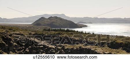 Stock Image - Rugged volcanic mountain landscape, moraine debris at the coastline. Fotosearch