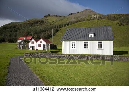 Stock Image - Rural farmyard with barn, houses, and church . Fotosearch