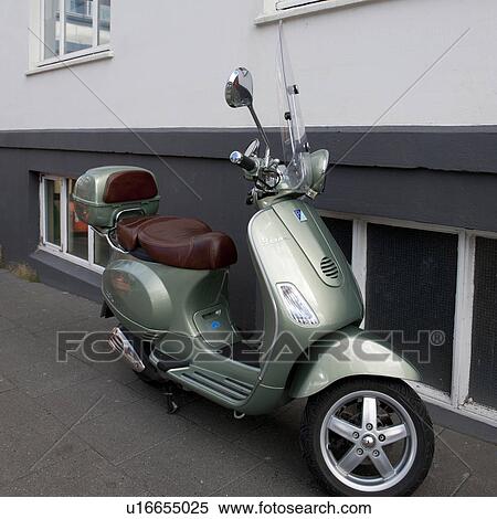 Stock Photography - Scooter parked beside building on sidewalk. Fotosearch