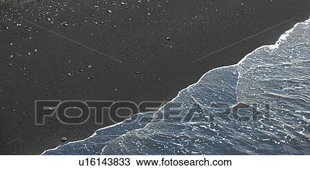 Stock Image - Seascape, waves breaking alond the sandy shore. Fotosearch