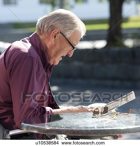 Senior adult male reading newspaper outside in the sun View Large Photo Image Picture - Senior adult male reading newspaper outside in the sun. Fotosearch