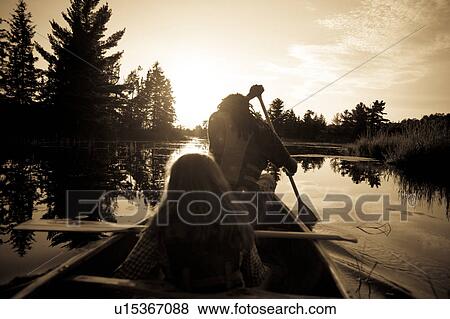 Sillhouette of people rowing a canoe at Lake of the Woods, Ontario View Large Photo Image Stock Photo - Sillhouette of people rowing a canoe at Lake of the Woods, Ontario. Fotosearch