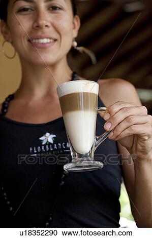 Stock Image - Smiling female barista with a three layered coffee beverage. Fotosearch