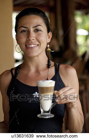 Smiling female barista with a three layered coffee beverage View Large Photo Image Stock Photo - Smiling female barista with a three layered coffee beverage. Fotosearch
