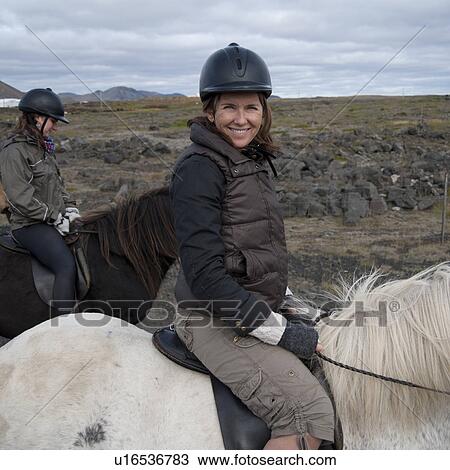 Stock Image - Smiling woman on horseback. Fotosearch