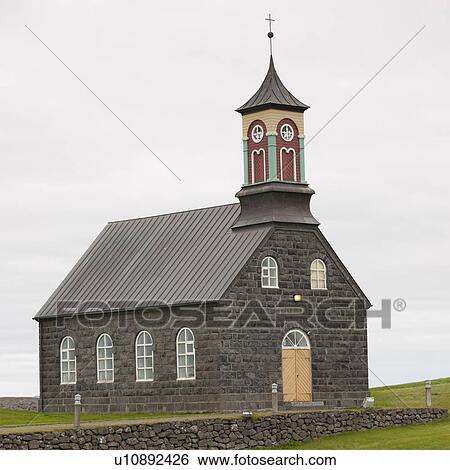 Stock Photograph - Stone block Christian church with stone fence. Fotosearch
