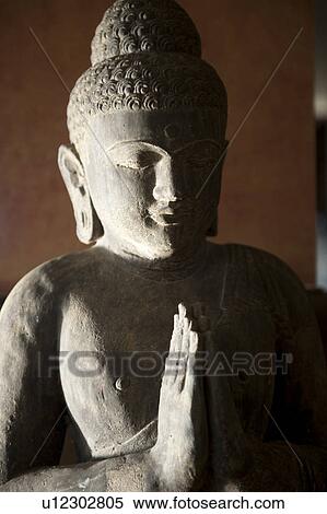 Stone Buddha statue with hands in prayer position with strong shadows View Large Photo Image Stock Photography - Stone Buddha statue with hands in prayer position with strong shadows. Fotosearch