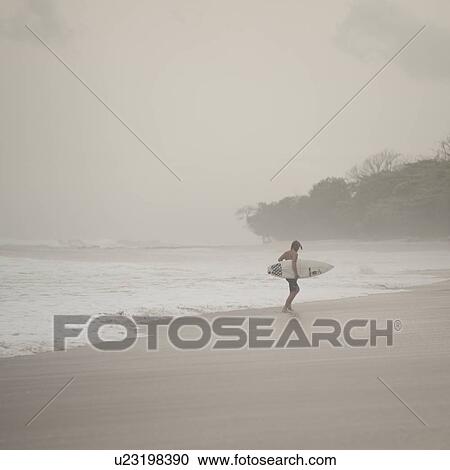 Surfer along Coast Rica shoreline View Large Photo Image Stock Image - Surfer along Coast Rica shoreline. Fotosearch