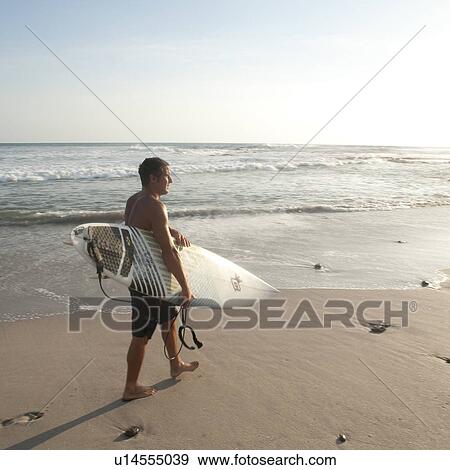 Stock Photo - Surfer along Costa Rica beach. Fotosearch